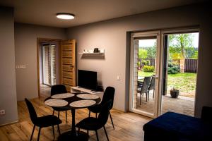 a living room with a table and chairs and a television at Vila „Prie tvenkinio“ in Palanga