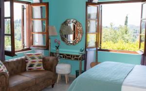 una camera con letto, sedia e specchio di The Little House Corfu ad Áno Korakiána