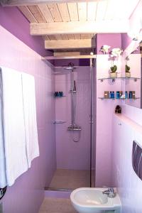 un bagno viola con doccia e lavandino di The Little House Corfu ad Áno Korakiána