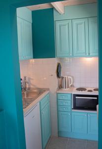una cucina con armadi blu e lavandino di The Little House Corfu ad Áno Korakiána