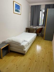 um quarto com uma cama, uma secretária e uma mesa em Hotel Bentley New em Bruxelas