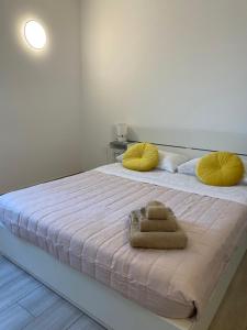 um quarto com uma cama grande e almofadas amarelas em Casa Emalí em Olbia