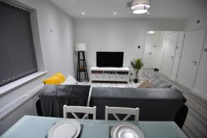 - un salon avec un canapé et une télévision dans l'établissement Cozy! 2-bedroom Exclusive Apartment near Bristol City Centre Easton Speedwell sleeps upto 6, à Bristol