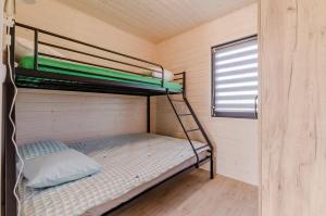 a bunk bed in a small room with a window at Domki letniskowe Krakowiak in Wicie