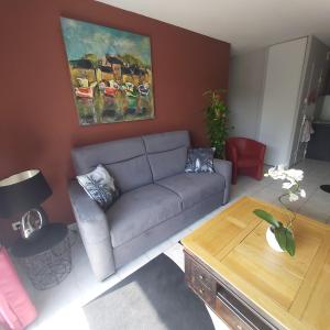 ein Wohnzimmer mit einem Sofa und einem Tisch in der Unterkunft Résidence privée Les Cottages in La Rivière Saint Sauveur