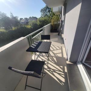 einen Balkon mit einem Tisch und Stühlen in der Unterkunft Résidence privée Les Cottages in La Rivière Saint Sauveur