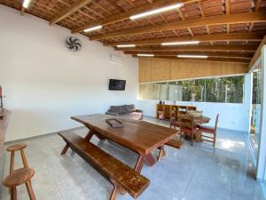 a living room with a wooden table and chairs at Chácara Toledo Costa in Itapeva