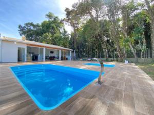 a swimming pool in front of a house at Chácara Toledo Costa in Itapeva +33 photos