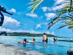 un grupo de personas en una piscina en el agua en Aqua Vista Villa, en Nusa Lembongan