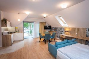 a bedroom with a bed and a table and a kitchen at Apartamenty Camping Morski in Łeba