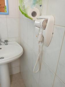 a white phone in a bathroom next to a sink at VILLA SISSY in Agia Paraskevi