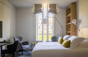 波尔多Villas Foch Boutique Hotel & Spa Bordeaux的卧室配有一张带黄色枕头的大型白色床。 更多37张照片