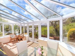 a conservatory with a glass roof with a table and chairs at The Cedars in Ambleside