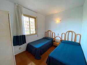 1 dormitorio con 2 camas y ventana en Apartamentos Decathlon, en Salou