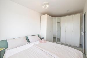 グリュックスブルクにあるfewo1846 - Del Mar - komfortable 2-Zimmer-Wohnung mit Balkon im 7 OGのベッドルーム1室(大型ベッド1台、白いキャビネット付)