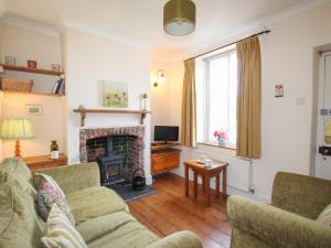 a living room with a couch and a fireplace at Poppy Cottage in Swanage