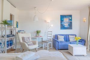 ein Wohnzimmer mit einem blauen Sofa und einem Stuhl in der Unterkunft fewo1846 - Sonne und Meer - kleines Studio-Apartment mit Balkon und Meerblick in Glücksburg