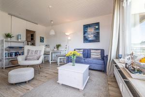sala de estar con sofá azul y mesa en fewo1846 - Sonne und Meer - kleines Studio-Apartment mit Balkon und Meerblick, en Glücksburg