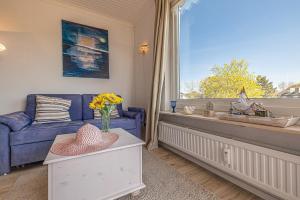 a living room with a blue couch and a window at fewo1846 - Sonne und Meer - kleines Studio-Apartment mit Balkon und Meerblick in Glücksburg +10 photos