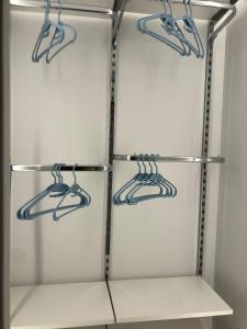 a white refrigerator with four shelves with blue hangers at Palazzina Margò in Mola di Bari