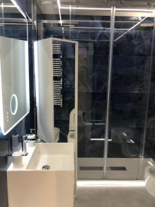 bagno con doccia in vetro e lavandino di Palazzina Margò a Mola di Bari