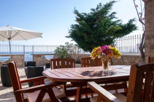 a wooden table with a vase of flowers on it at Villa Giada on The Sea in Polignano a Mare
