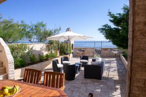 a patio with a table and chairs and an umbrella at Villa Giada on The Sea in Polignano a Mare