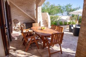 a wooden table and chairs on a patio at Villa Giada on The Sea in Polignano a Mare +31 photos