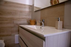 a bathroom with a white sink and wooden walls at Villa Giada on The Sea in Polignano a Mare