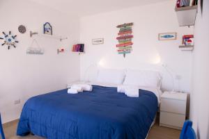 a bedroom with a blue bed with towels on it at Villa Giada on The Sea in Polignano a Mare