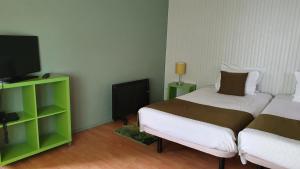 a bedroom with a bed and a tv and a bedskirts at Hospedaria 5 Bicas in Aveiro