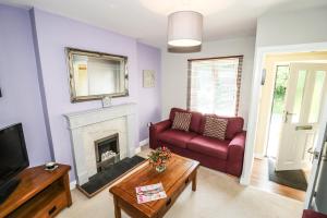 a living room with a red couch and a fireplace at Roecliffe in Boroughbridge
