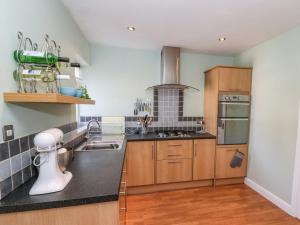 a kitchen with wooden cabinets and black counter tops at Roecliffe in Boroughbridge