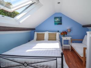 een bed in een kamer met blauwe muren en een raam bij Roecliffe in Boroughbridge