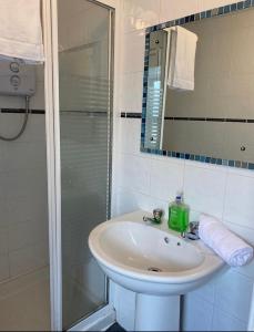 a white bathroom with a sink and a shower at Cheap Budget Accommodation in Galway