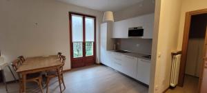 a kitchen with white cabinets and a table with chairs at Ca' de l'Achille in Torri del Benaco
