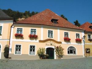 ein großes weißes Gebäude mit Blumen in den Fenstern in der Unterkunft Gästehaus Huber in Weissenkirchen in der Wachau