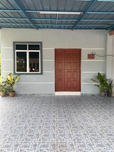 a red door on the side of a house at Makndak Roomstay in Arau +9 photos