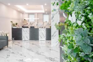 an office lobby with marble floors and plants at Hotel Class in Oradea