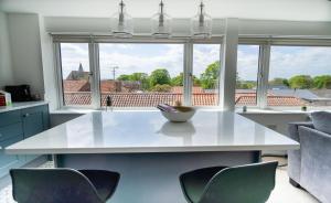 a kitchen with a table and chairs and a large window at 'The View' Penthouse Apartment Number Four Lees Terrace in Holt
