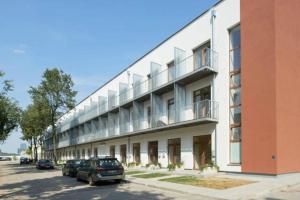 un grand bâtiment avec des voitures garées devant lui dans l'établissement Natalex MicroLofts, à Vilnius