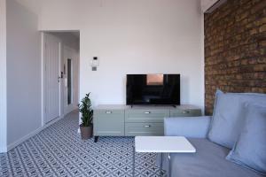 Una sala de estar con un sofá azul y un televisor. en Sunflower Apartments, en Estambul