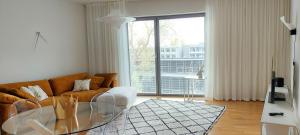 a living room with a couch and a glass table at Seedri Breakwater Residence with Private Parking in Pärnu