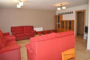 a living room with two red couches and a living room with at Holiday home Casa las Margaritas in Salamanca