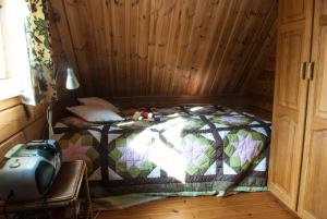 a bedroom with a bed in a wooden room at Vindheimar Cottage - Great View - Hot Tub in Skeljabrekka