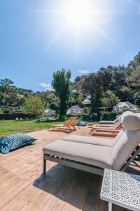 a bed sitting on a wooden deck with the sun at Les Cabanons de l'Ouille in Collioure