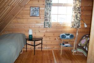 a bedroom with a bed and a table with a lamp at Vindheimar Cottage - Great View - Hot Tub in Skeljabrekka