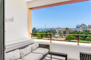 Una sala de estar con un sofá y una ventana grande. en Limassol Marina Nereids D22 by Ezoria Villas, en Limassol