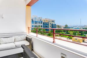 balcón con sofá y vistas a la ciudad en Limassol Marina Nereids D22 by Ezoria Villas, en Limassol