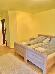 Duas camas num quarto com uma parede amarela em Sailor's Apartman em Siófok